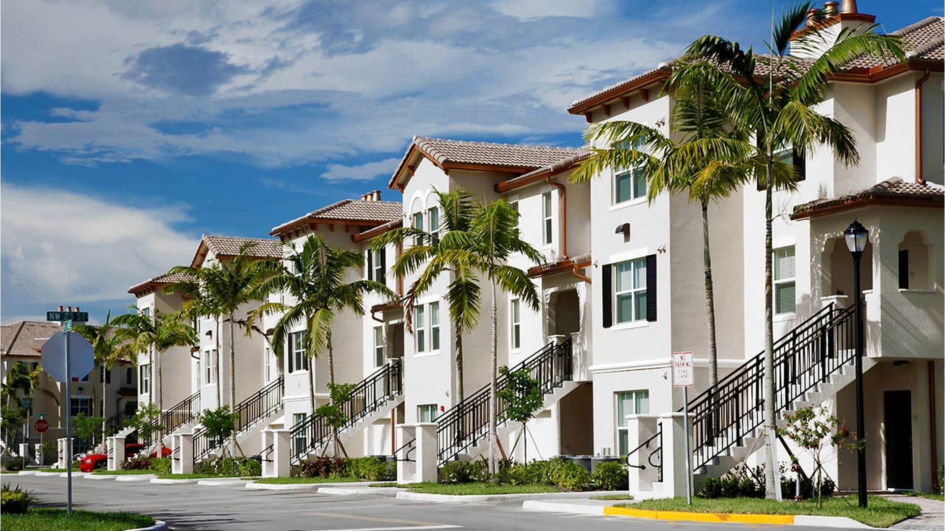 front shot of condo buildings in a beachy area